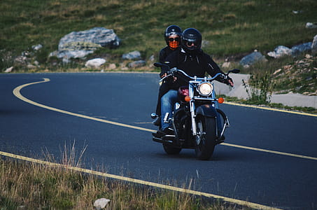 two person riding motorcycle beside grass field thumbnail