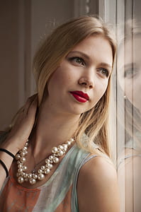 woman wearing teal and orange tank top leaning on glass wall thumbnail
