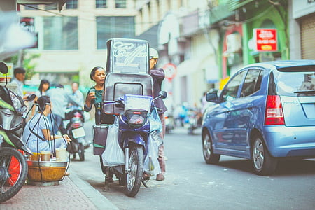 two people loading cargo on motorcycle beside road thumbnail