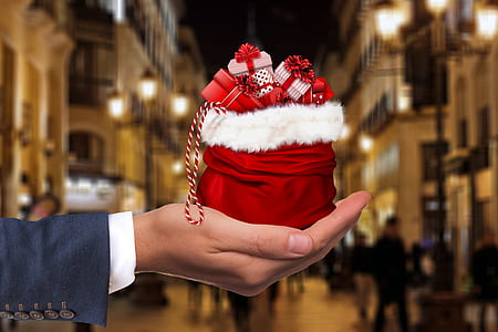 shallow focus photography of person holding gift boxes thumbnail