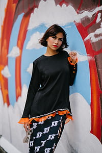 Woman Wearing Black Long-sleeved Shirt Learning on Wall thumbnail