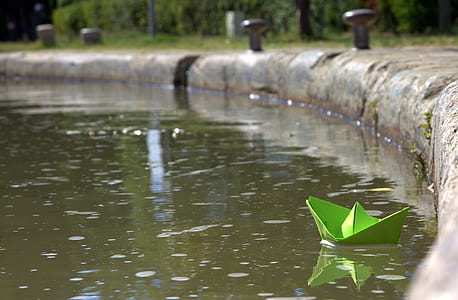 green paper boat on pond thumbnail