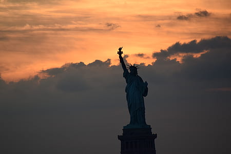 silhouette of the Statue of Liberty during golden hour thumbnail