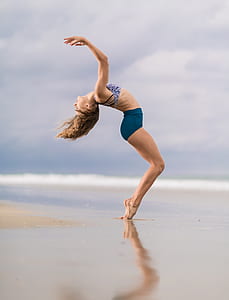 woman bending her body in sea shore thumbnail