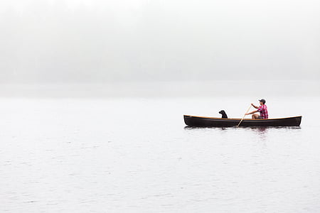 man paddling on boat with dog on board thumbnail