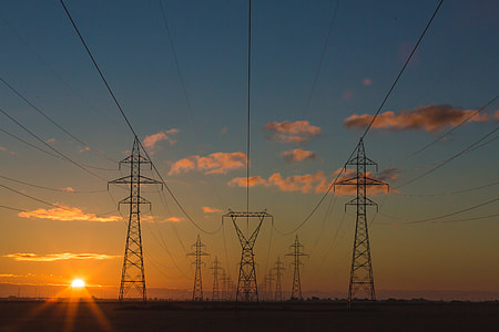 photo of transmission tower under clear blue sky during golden hour thumbnail