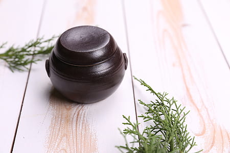 round black clay container on brown wood thumbnail