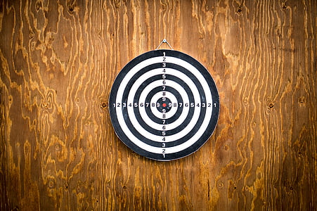 black and white dartboard hanged on wooden wall thumbnail