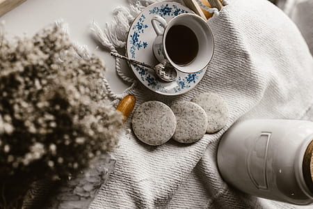 white teacup filled with black liquid on saucer thumbnail