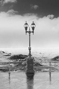 grayscale photo of lamp post near on seashore thumbnail
