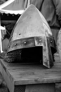 grayscale photo of knight helmet on table thumbnail