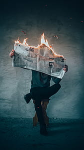 person holding burning newspaper thumbnail