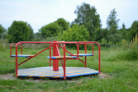 red, blue, and yellow spinning playground at daytime thumbnail