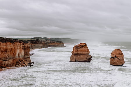 landscape photography of two rock formation on sea thumbnail