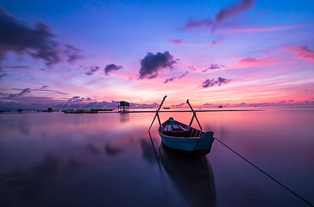 canoe on body of water with blue and pink sky thumbnail