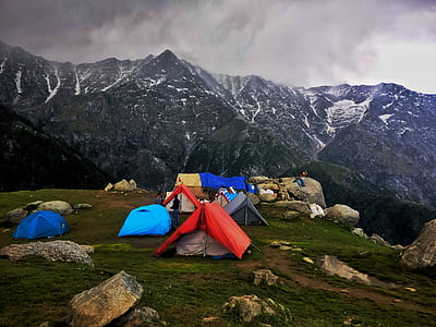 people camping at top of hill with view of mountain range thumbnail
