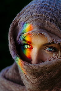 woman covered with beige scarf taking a selfie thumbnail