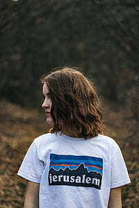selective focus photography of woman wearing white Jerusalem-printed shirt looking at right side thumbnail