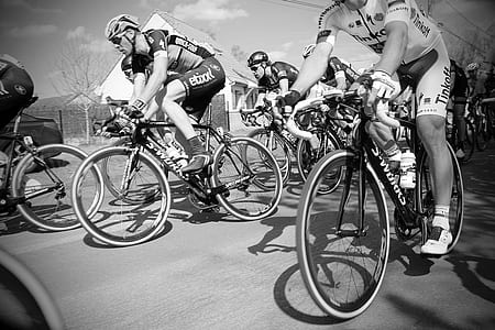 grayscale photo of group of people ride on bikes thumbnail