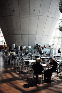 two persons sitting on chair in front of table near commercial deks thumbnail