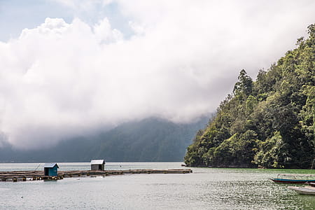Oceanside mountains covered with clouds in Indonesia thumbnail
