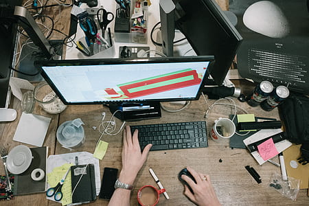 person using desktop computer on wooden table thumbnail