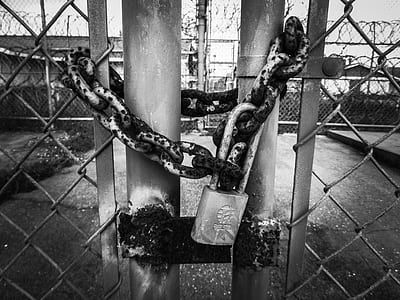 grayscale photography of gate with padlock thumbnail