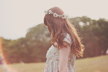 woman wearing pink and gray floral dress with white petaled flower headdress thumbnail