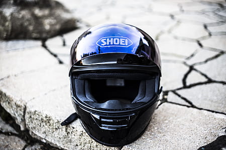 black Shoei full-face helmet on top of grey stone fragment thumbnail