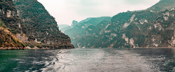 body of water near mountain during daytime thumbnail