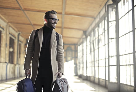 Man in Brown Robe Carrying Bag Smiling thumbnail