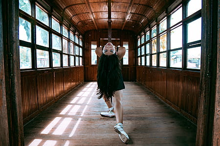 woman in black top bending her body in brown wooden store thumbnail
