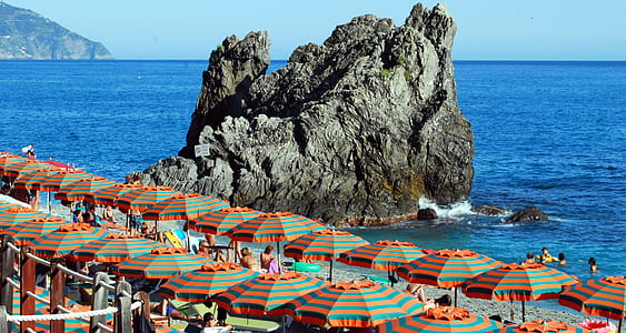 umbrellas by the shoreline near rock mountain thumbnail