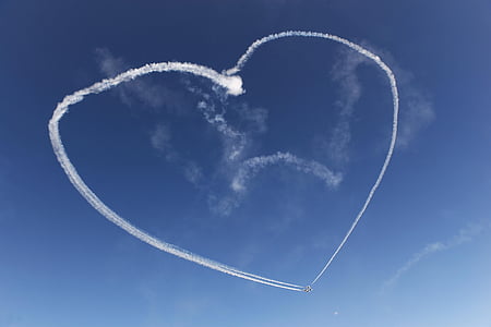 plane with smoke forming heart on sky thumbnail