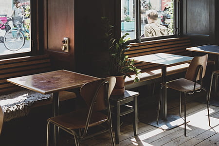 two squared brown tables and chairs inside room thumbnail