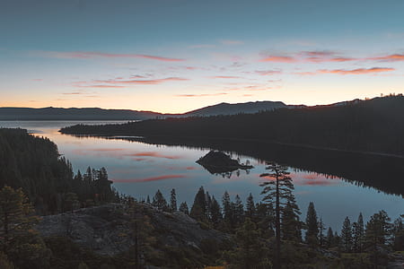 landscape photography of lake between trees thumbnail