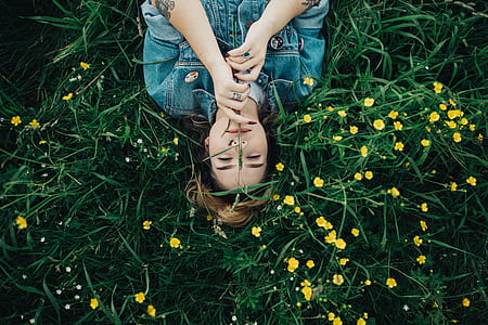 woman laying on green grasses thumbnail