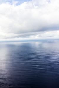 body of water under white cloudy sky thumbnail