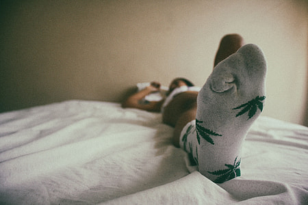 A woman lying in house bedroom wearing socks on her feet thumbnail