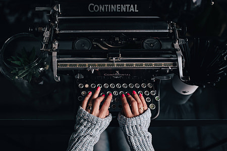 Woman typing on an old typewriter thumbnail