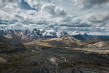 bird's eye view photography of road towards mountains thumbnail