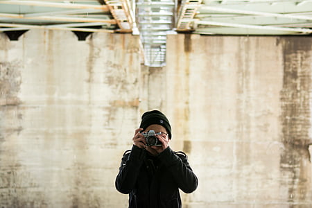 person wearing black top using camera thumbnail