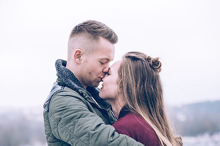 selective focus photography of man kissing woman in nose thumbnail