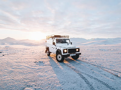 white SUV on snow coated land thumbnail