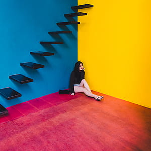 woman sitting on corner under stairs thumbnail