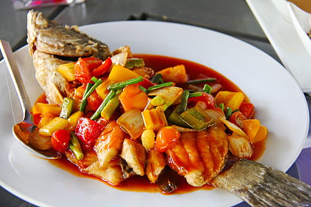 cooked fish with sauce on round white plate thumbnail