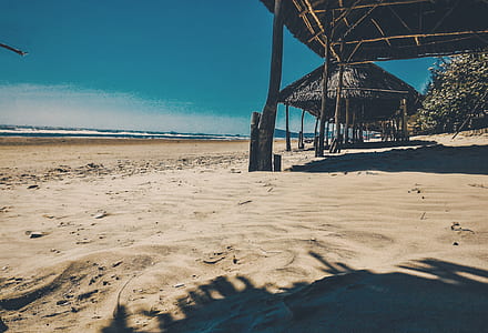Brown Nipa Cottage Near Ocean at Daytime thumbnail
