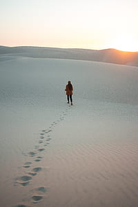 person walking on sand during daytime thumbnail