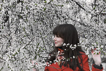woman wearing red coat standing near tree during daytime thumbnail