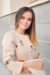 woman standing beside gray concrete building thumbnail